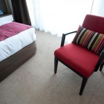 chambre avec fauteuil rembourré et coussins et rideaux